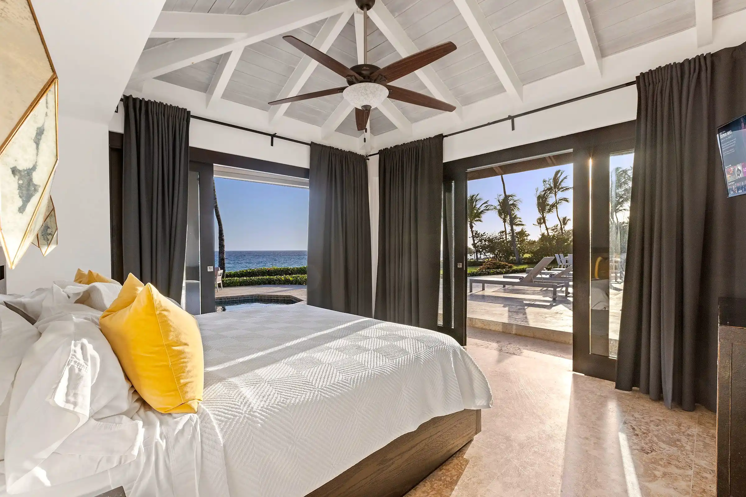 Bedroom at Costa Verde 3 with the Caribbean visible through a full-height window beside the bed
