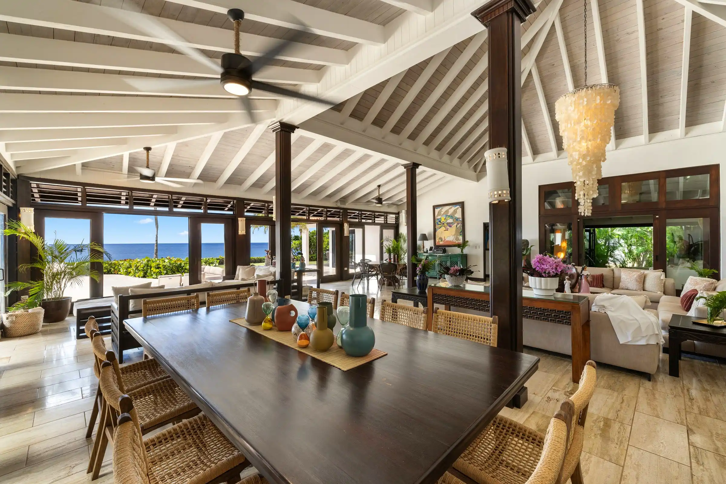 Open-plan dining and living at Costa Verde 3, timber screens dividing the two beneath a single beamed roof