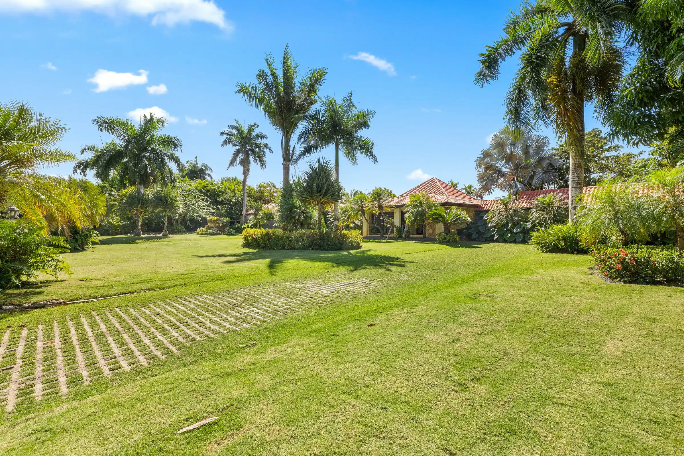Mature royal palms and tropical planting framing the gardens at Costa Verde 3, Casa de Campo