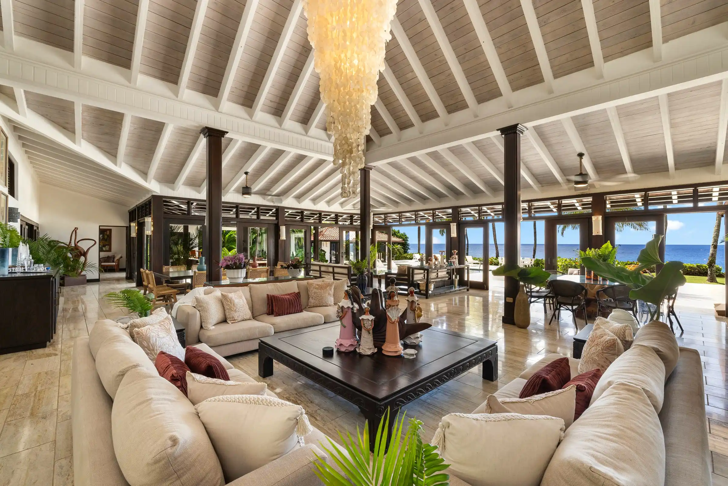 The great room at Costa Verde 3 beneath soaring beamed ceilings, opening down its full length to the Caribbean