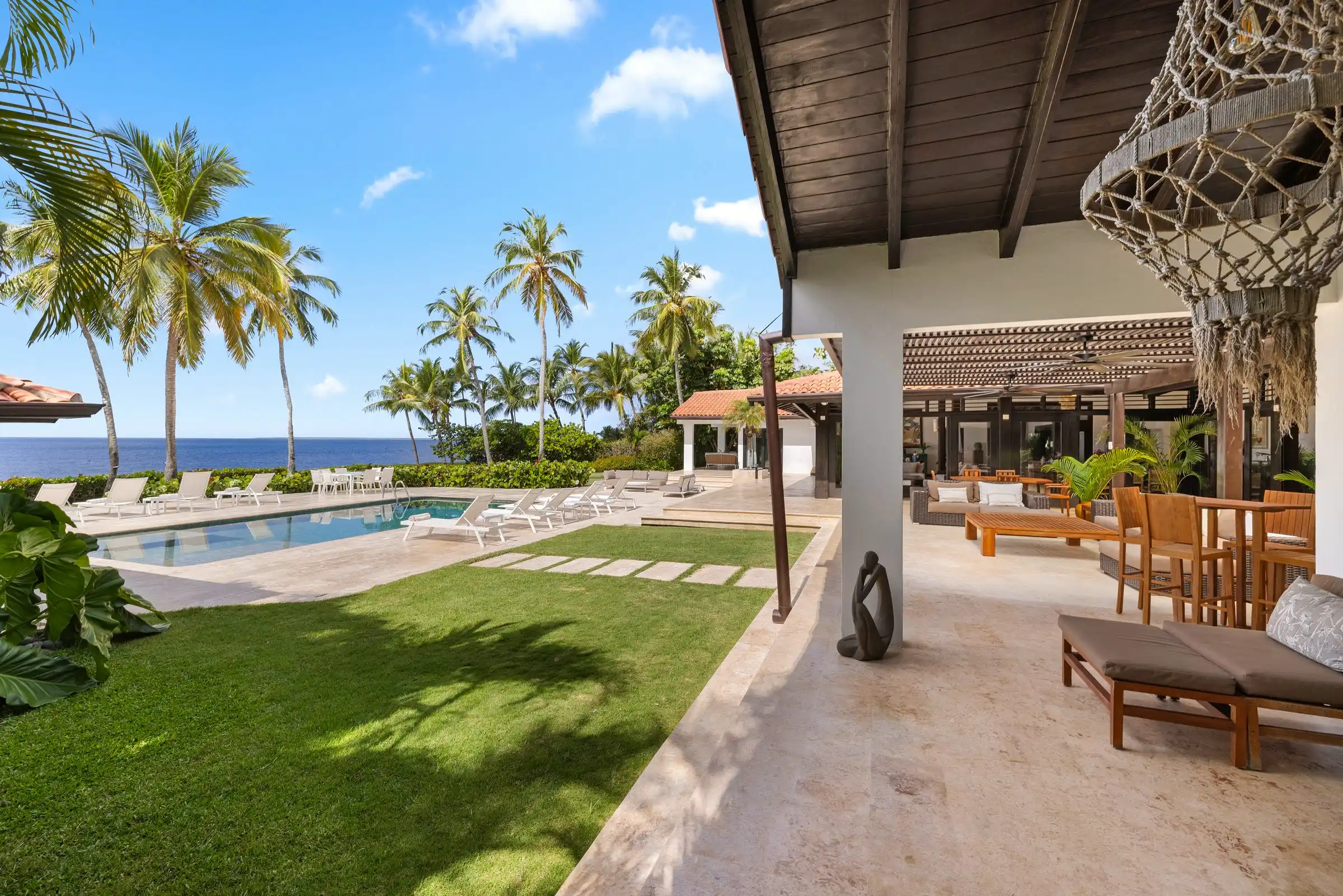 The lawn, covered terrace and pool at Costa Verde 3 with the Caribbean along the far edge