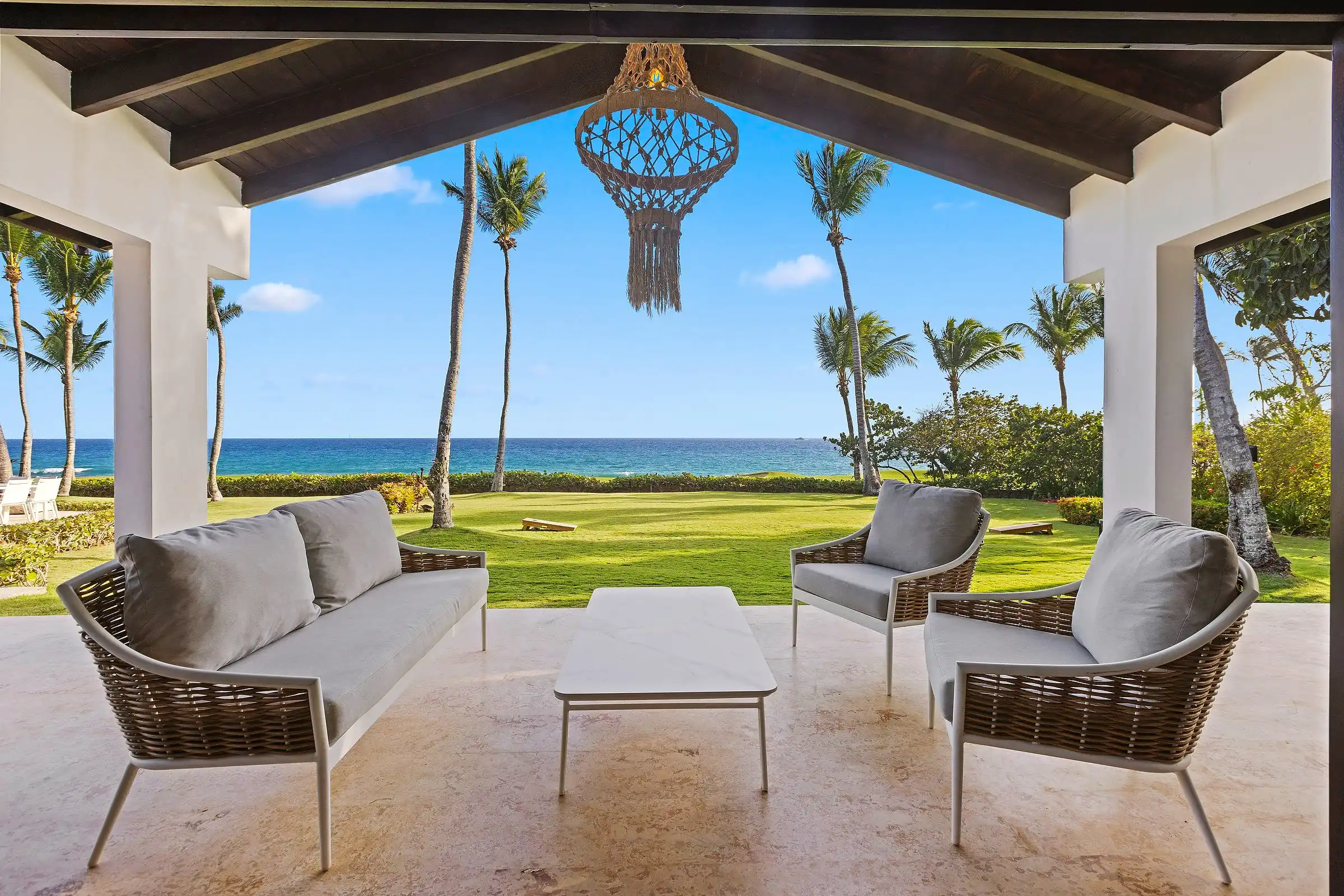 Loggia seating at Costa Verde 3 framed by columns, the fairway and open Caribbean directly ahead