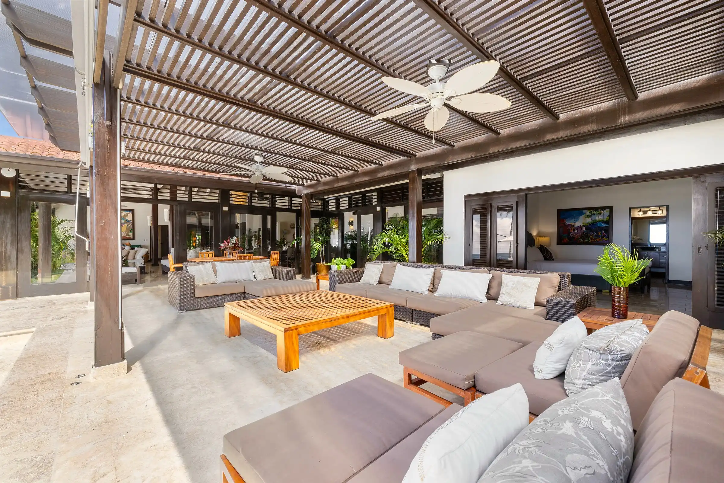 The open-air living pavilion at Costa Verde 3, sofas and a low timber table beneath the beamed roof