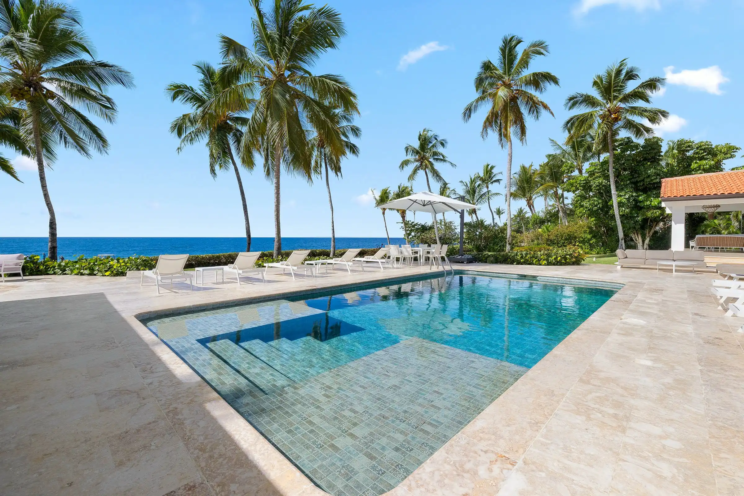 Palms and the pool at the ocean's edge at Costa Verde 3, Casa de Campo