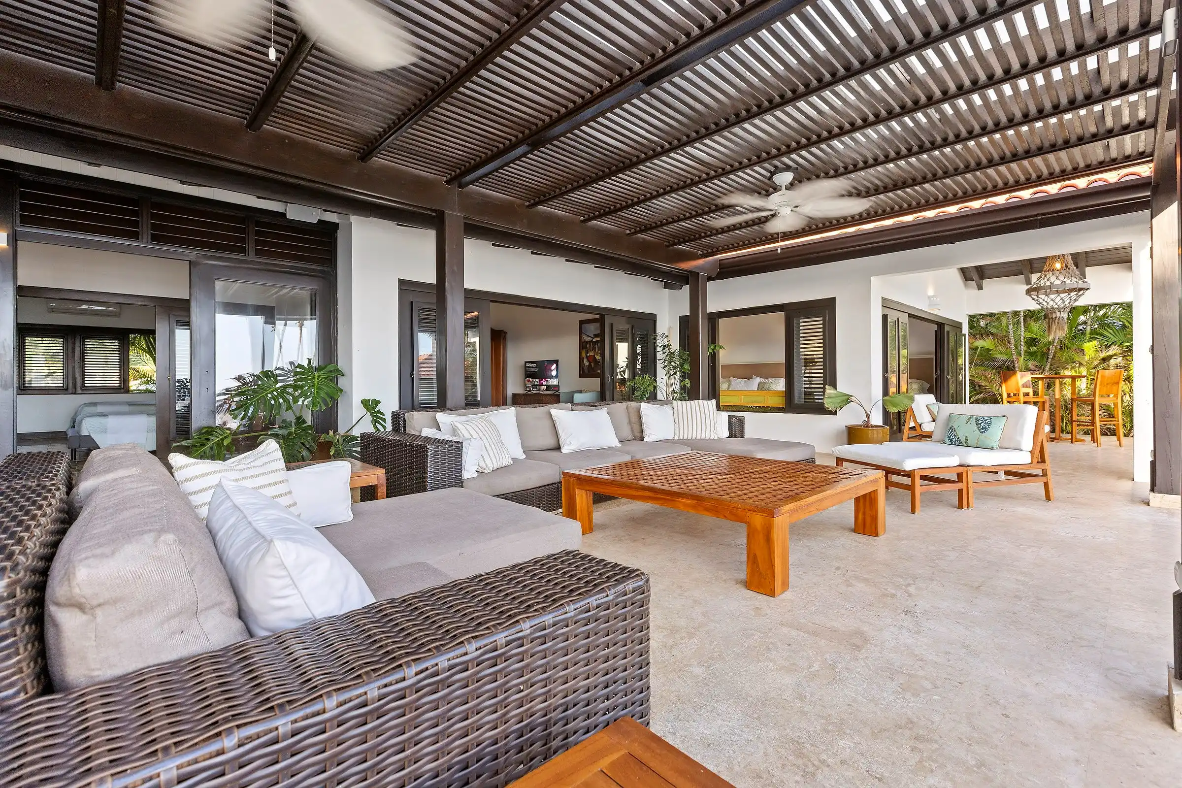 Pergola lounge at Costa Verde 3, wicker sofas and a teak table under a slatted timber roof
