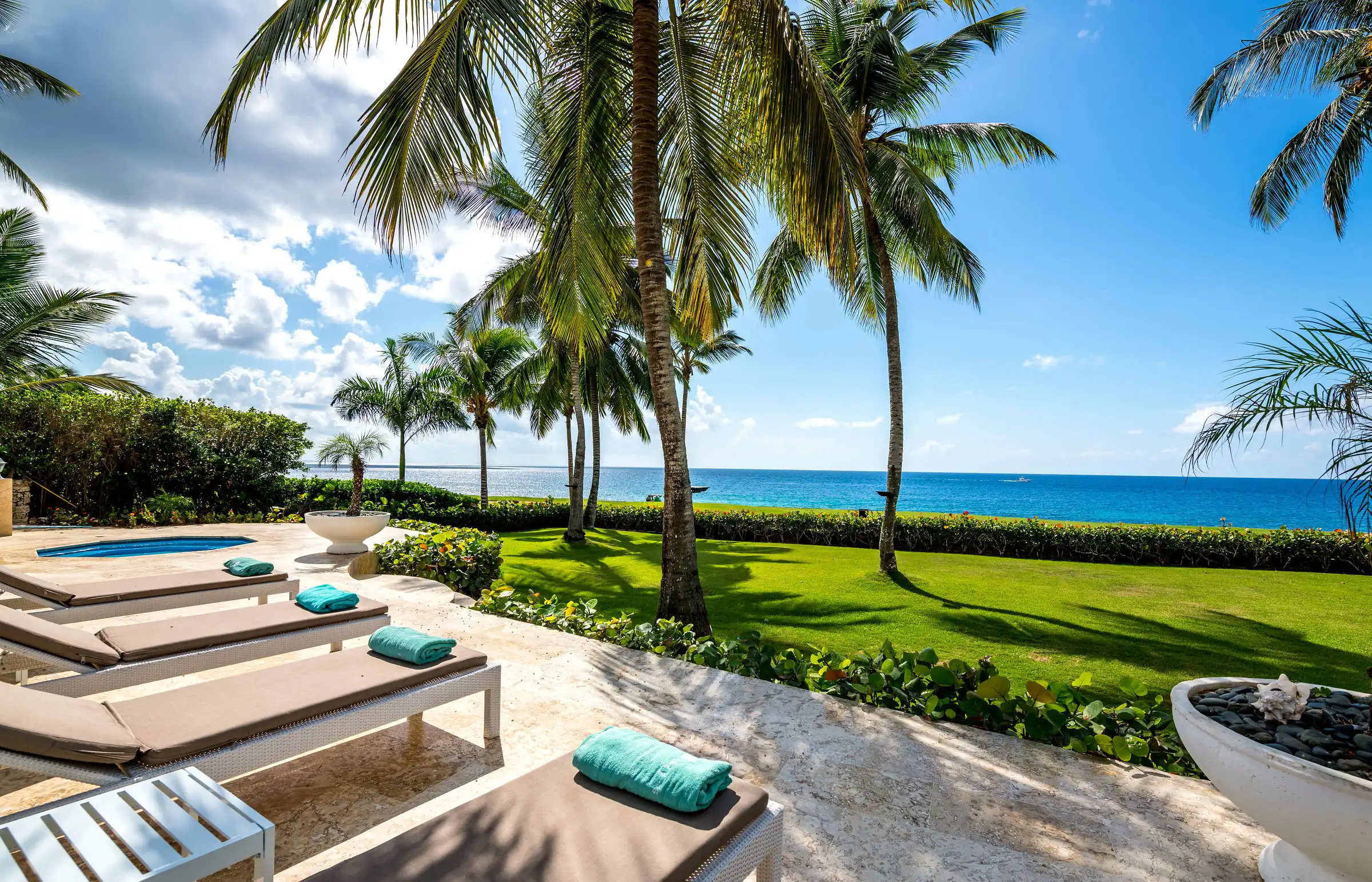 Pool, lawns and palms running to the water's edge at Costa Verde 3, Casa de Campo