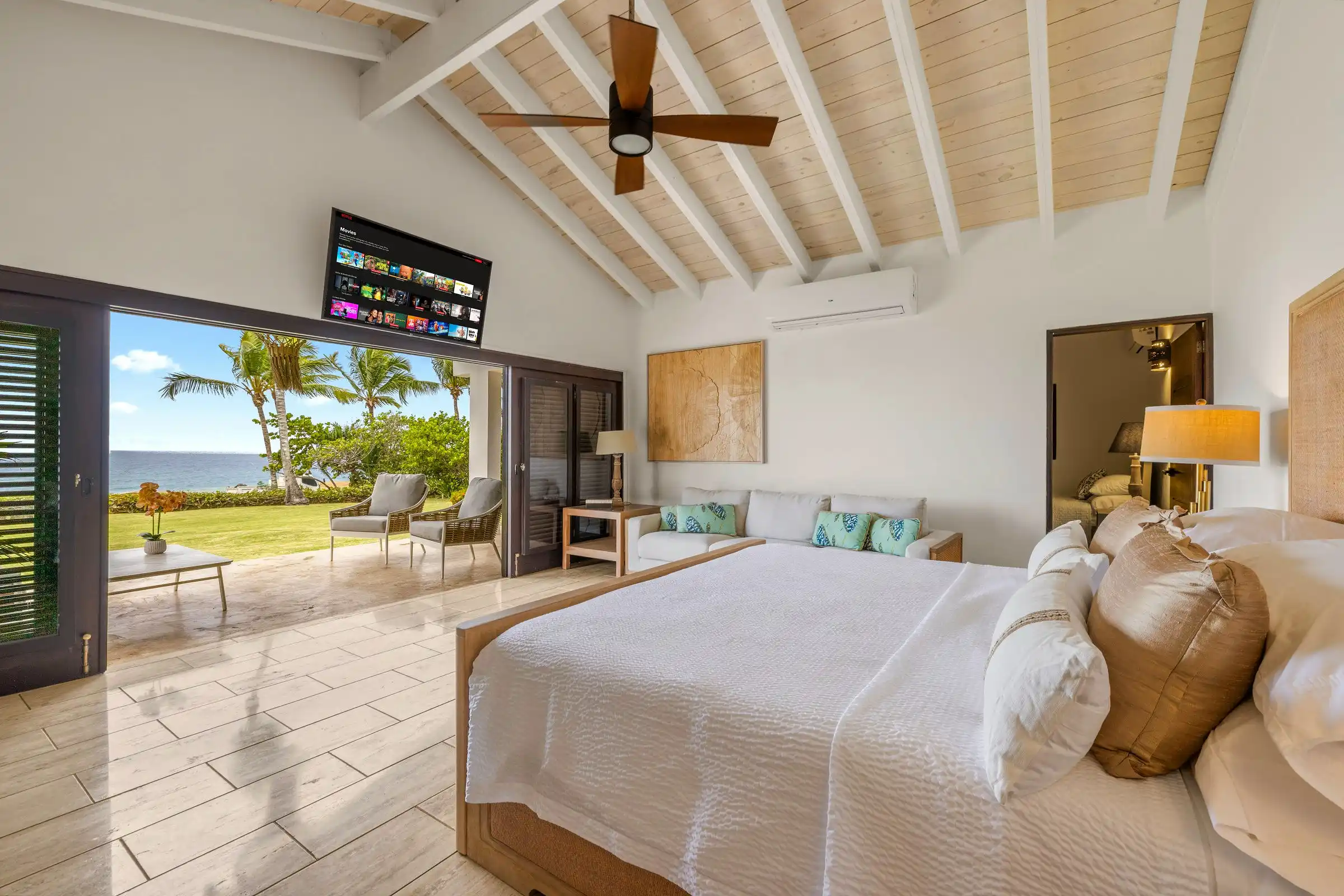 The primary suite at Costa Verde 3 opening directly to the lawn and the Caribbean beyond
