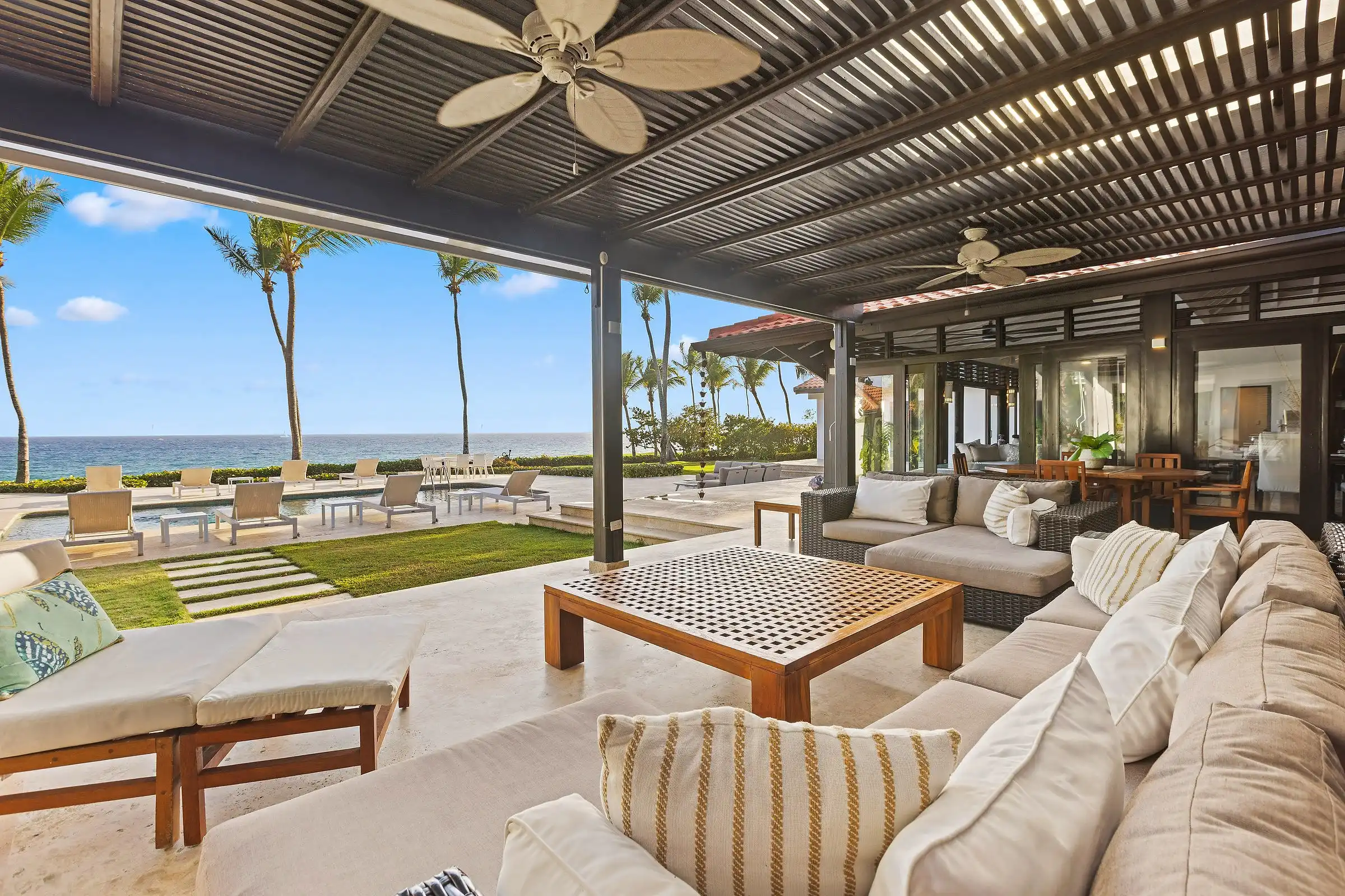 Shaded terrace lounge at Costa Verde 3 looking across the lawn and pool to the Caribbean