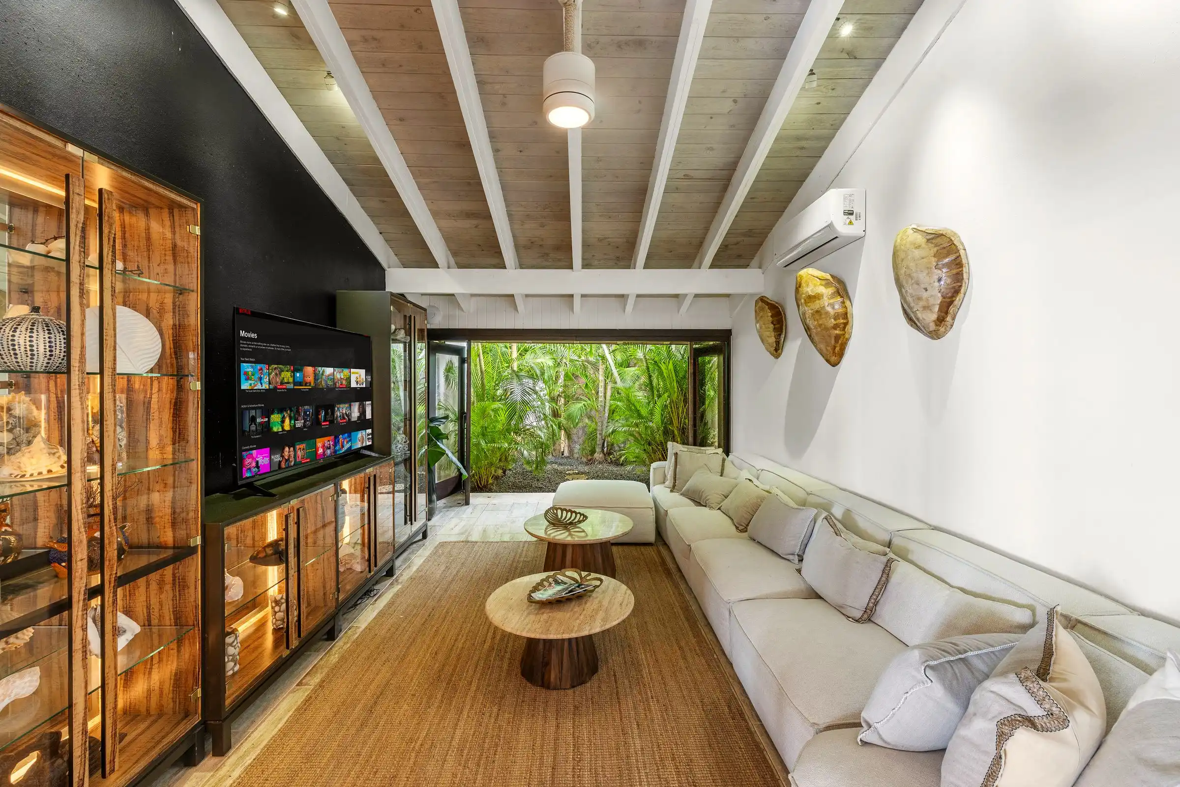 A second sitting room at Costa Verde 3 with a long banquette and tropical hardwood cabinetry