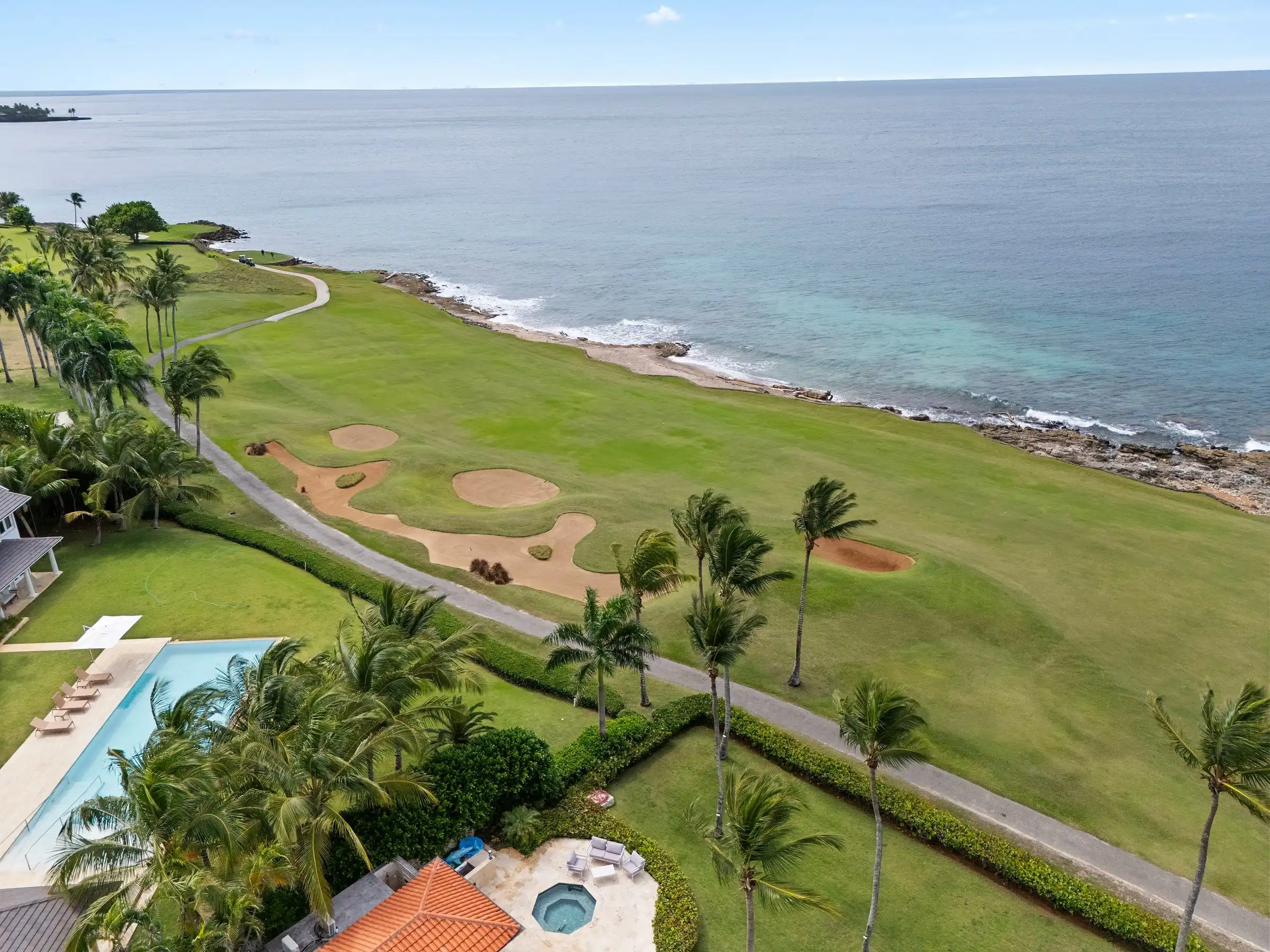 Aerial along the Caribbean shoreline showing the fairway and bunkers of Teeth of the Dog running to the rocks and open sea at Casa de Campo