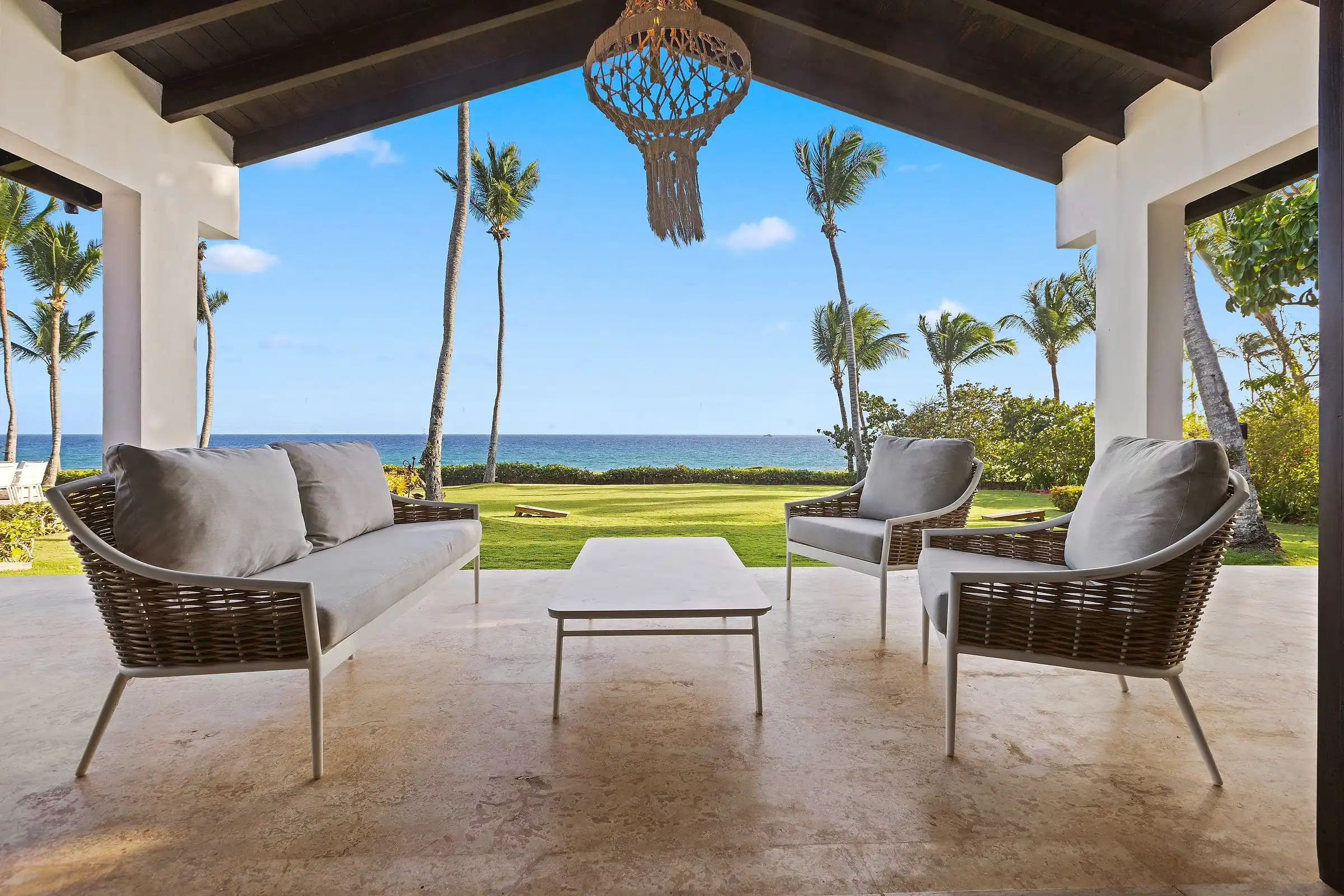 The covered terrace at Costa Verde 3 looking out between palms over the 8th fairway of Teeth of the Dog to the Caribbean