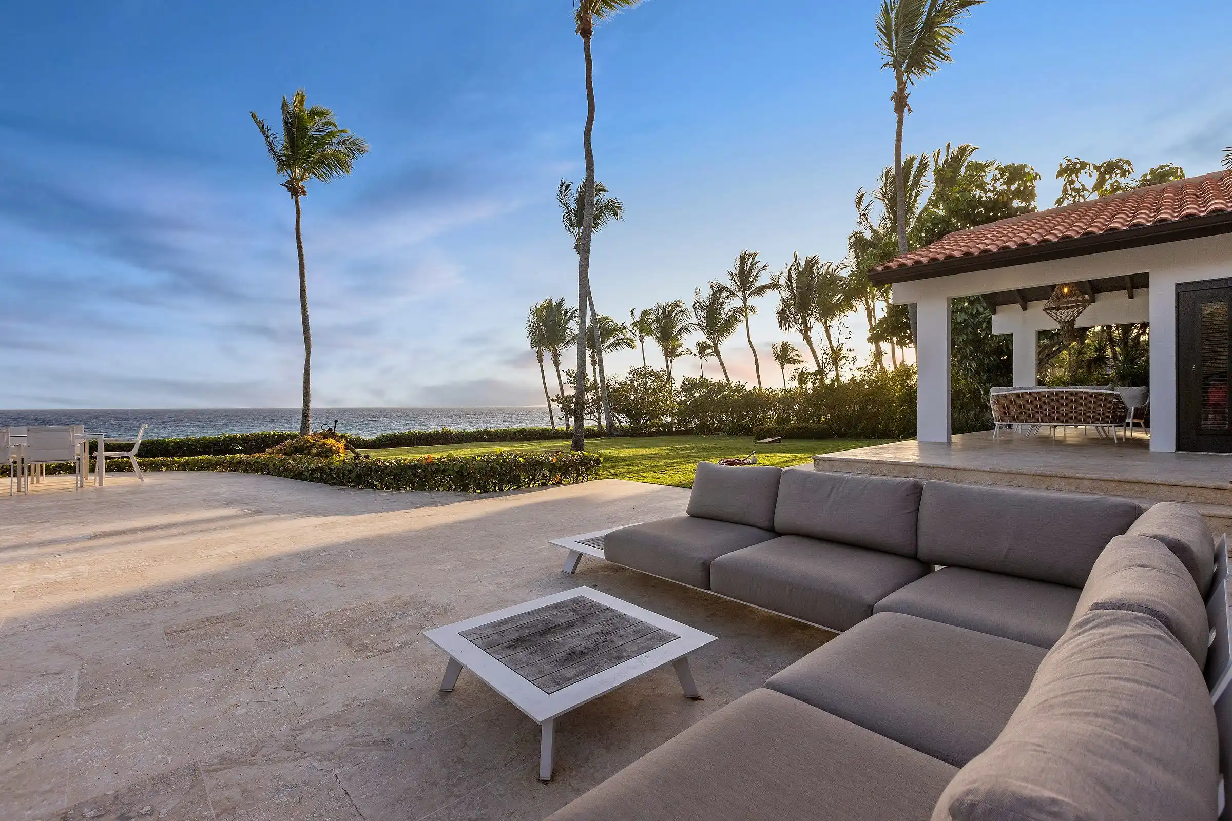 Terrace seating at Costa Verde 3 in the last light, palms and the Caribbean filling the view