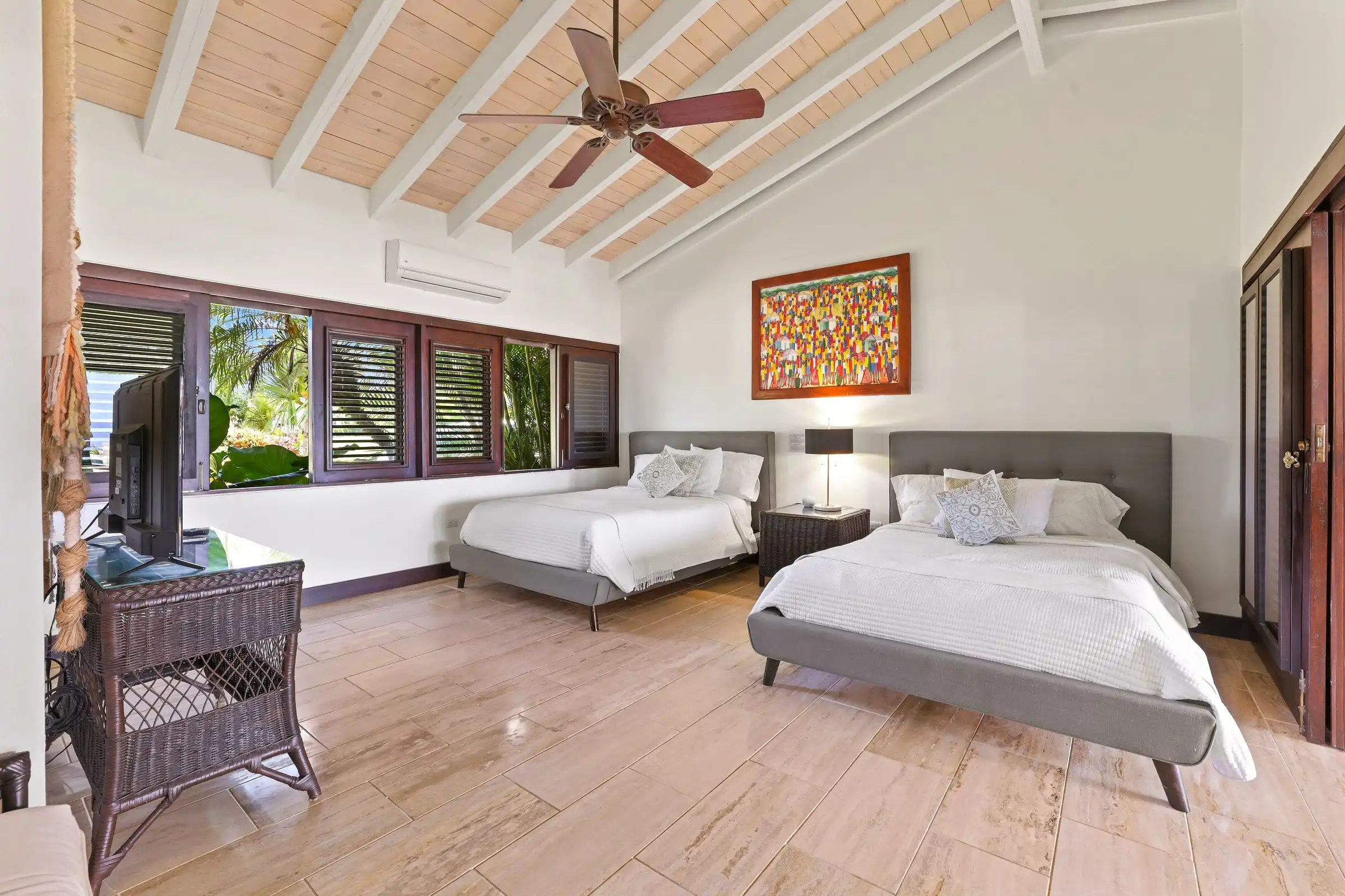 Twin guest bedroom at Costa Verde 3 with shuttered windows and an ocean view